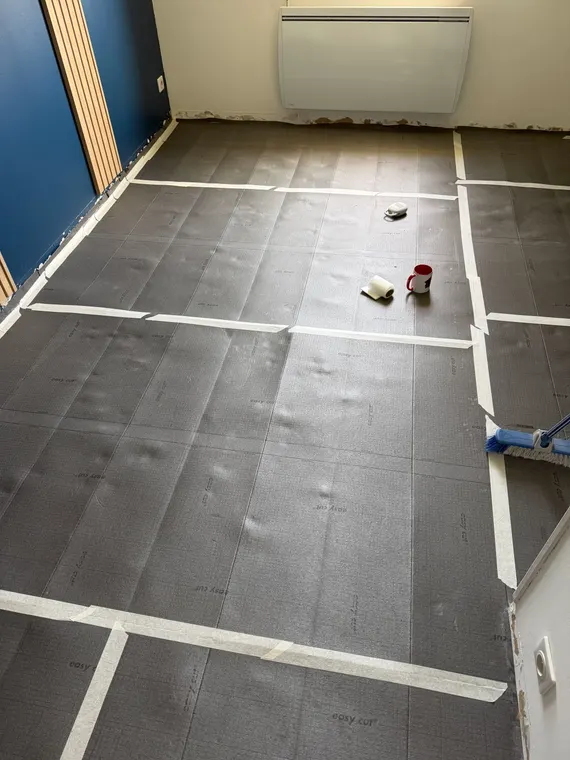 Underlay rolled out across the whole room, strips laid edge to edge and taped together